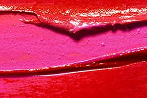 Thick red paint on a pink surface