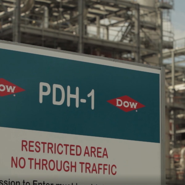 A close up of a Dow restricted area sign in front of a Dow facility