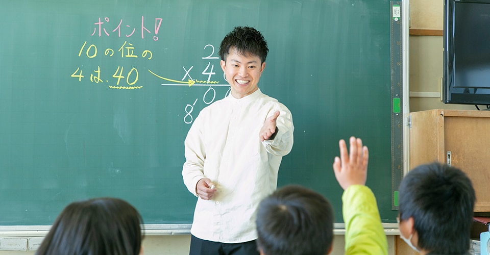 a smiling teacher engages with his students