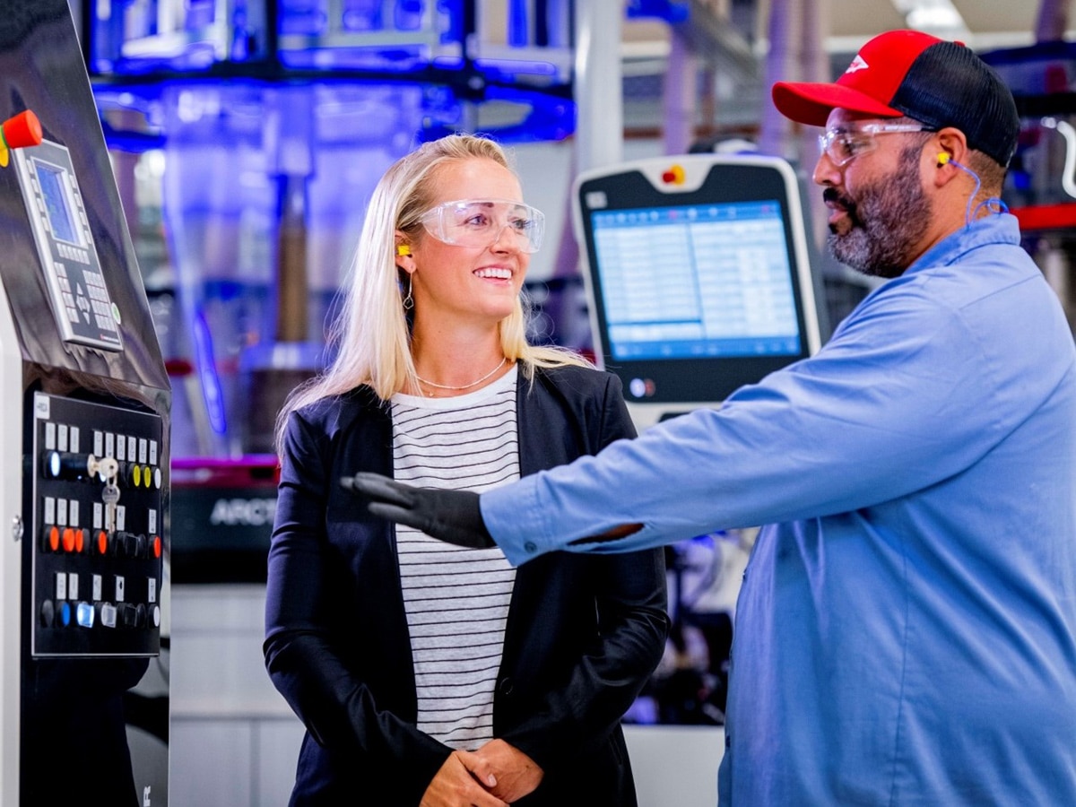 a Dow technician talking about a piece of manufacturing equipment with a female colleague
