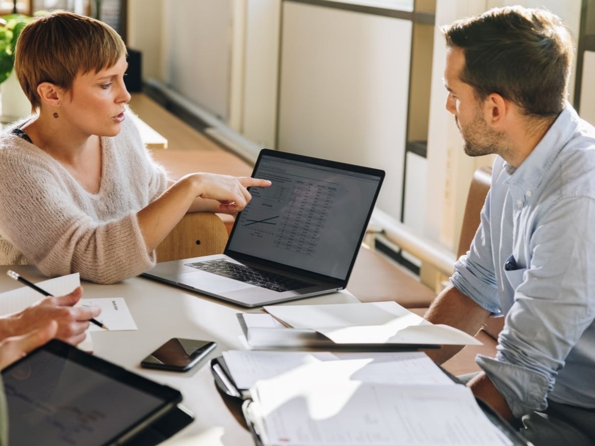 two people in a meeting looking at a laptop computer