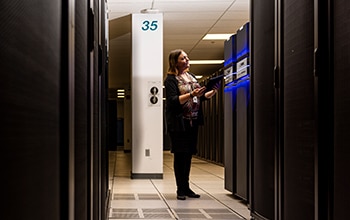 Woman monitoring equipment in a server room Woman monitoring equipment in a server room