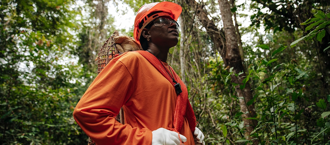 Person in an orange outfit standing in the Amazon rainforest Person in an orange outfit standing in the Amazon rainforest