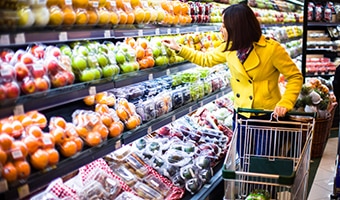 Woman looking at produce in the grocery store aisle Woman looking at produce in the grocery store aisle