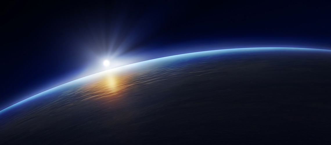 View of the sun rising behind the earth from space View of the sun rising behind the earth from space