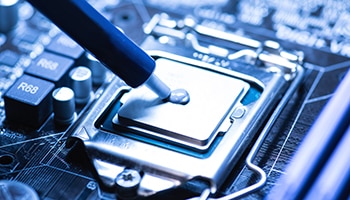 Adhesive being applied to a computer chip Adhesive being applied to a computer chip