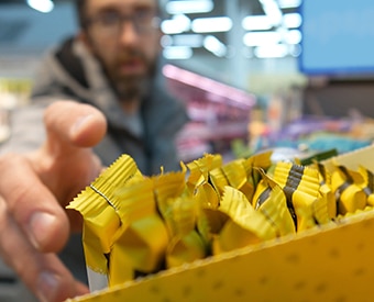Man reaching for a packaged snack Man reaching for a packaged snack