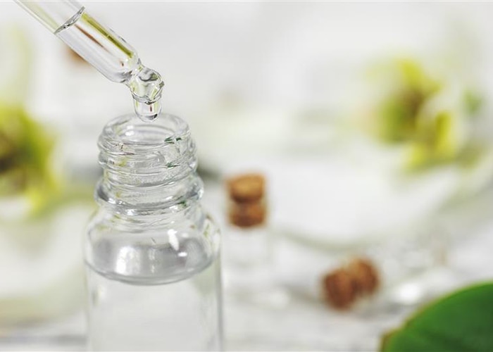 Close up of pipette and vial with clear fluid