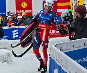 A Team USA Luger carries his sled to the starting line