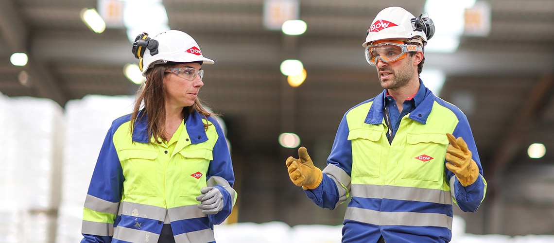 Two employees talking wearing PPE