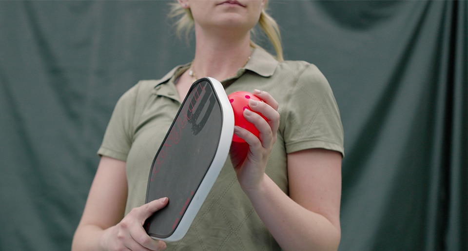 Header photo of woman holding a Wilson pickleball paddle and ball