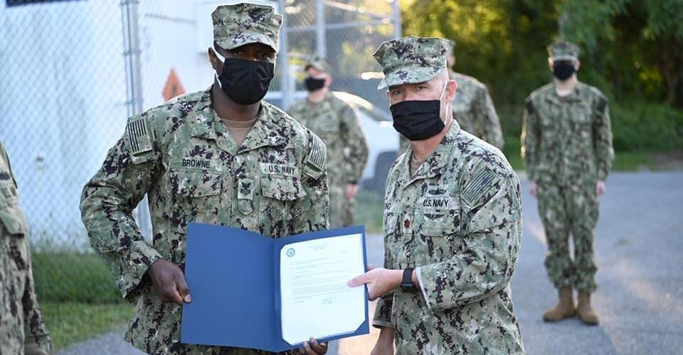 Military officer presents certificate to a serviceman