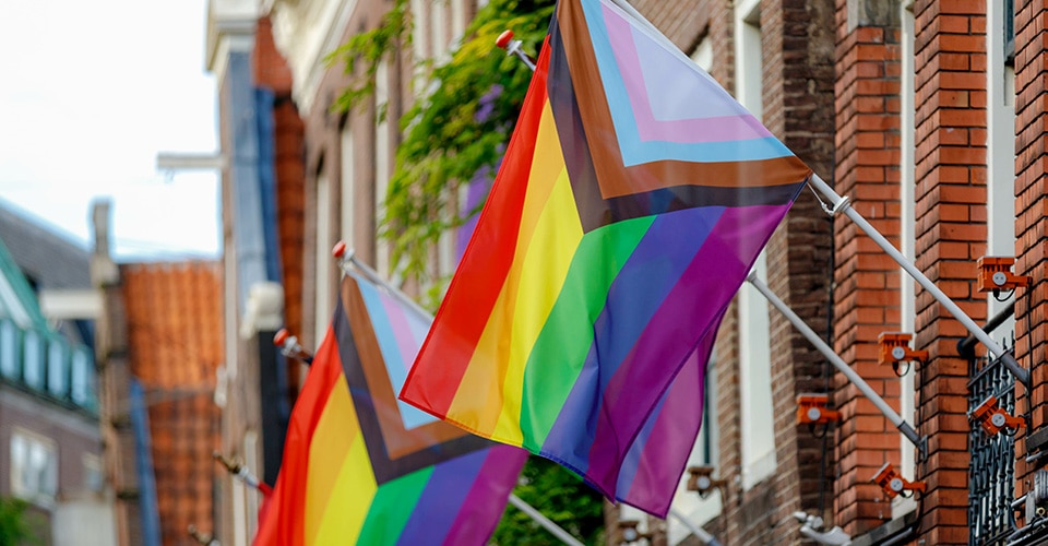pride flags flying from brick buildings