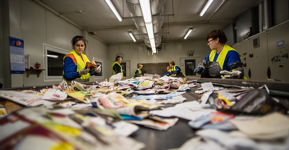 Workers sort materials for recycling