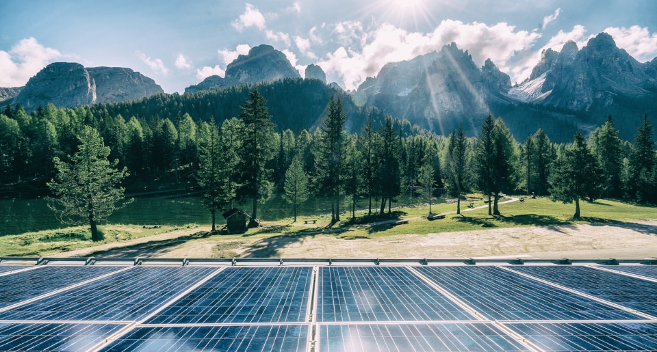 Solar panels surrounded by trees and mountains