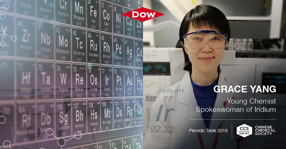 Grace Young smiles at the camera next to a graphic of the periodic table of elements