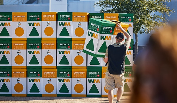 A volunteer prepares recycling containers for use at the WM Phoenix Open..