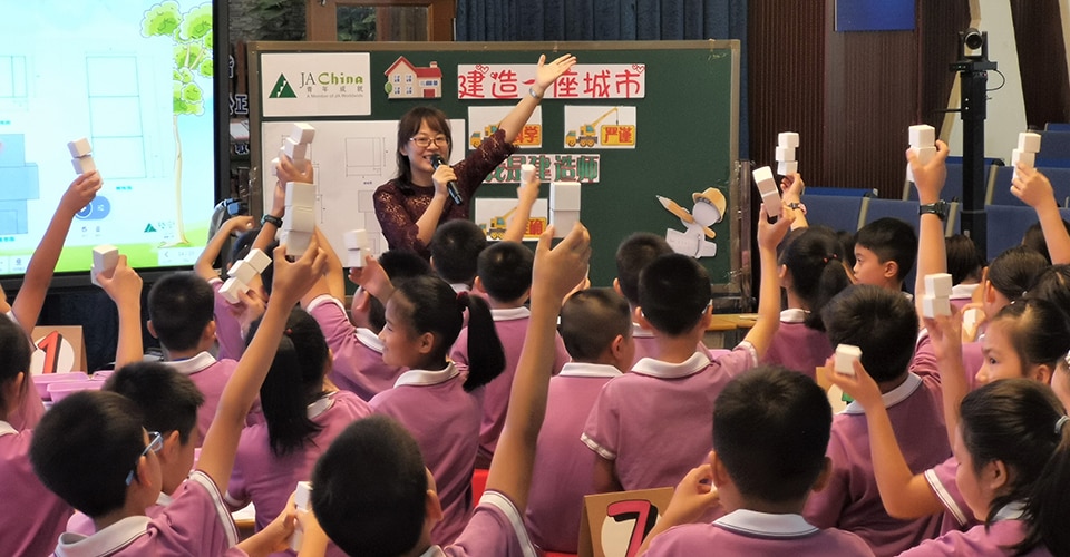 children raising hands in class