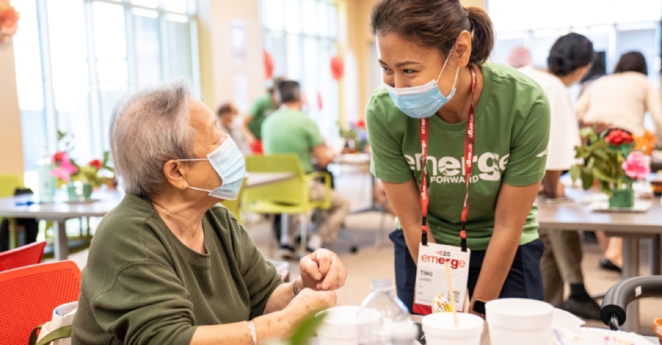 Team Dow volunteer speaks with an elderly woman at an event