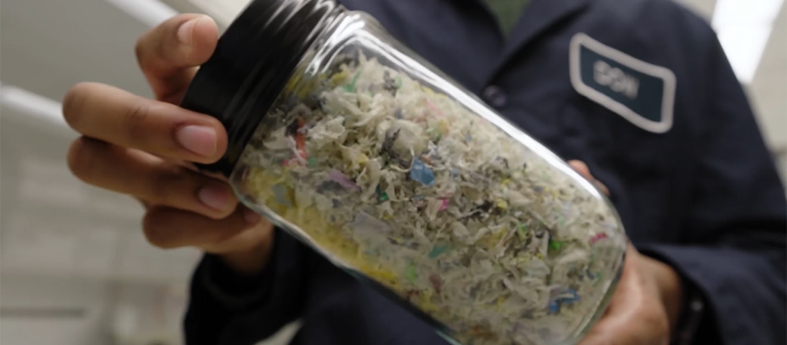 Dow scientist holding a jar of recycled plastic material