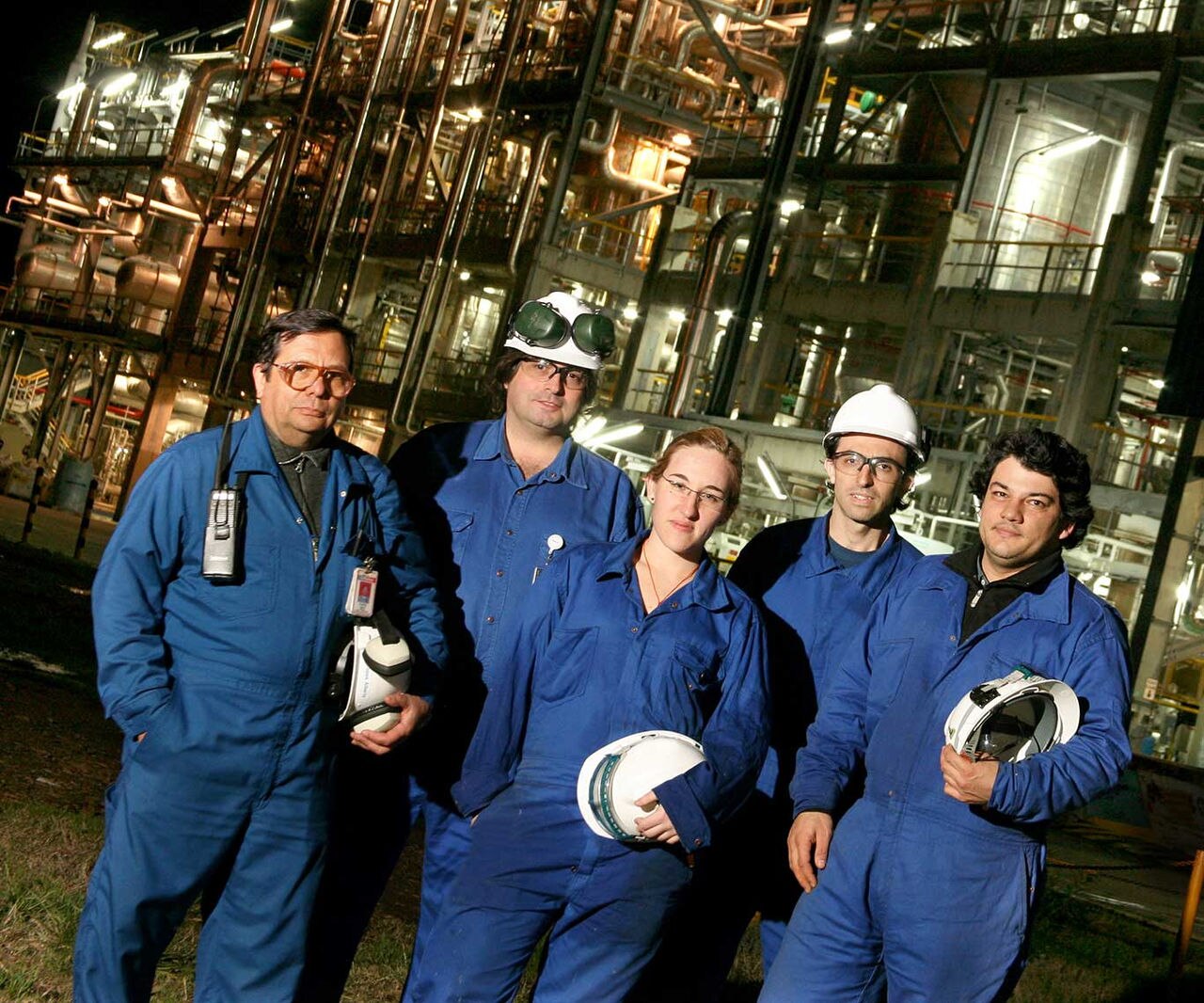 Five Dow factory workers standing in a group holding hard hats