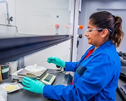 woman weighs material in a lab