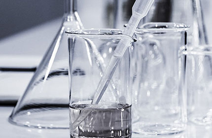  A beaker with a clear liquid in it surrounded by other glassware