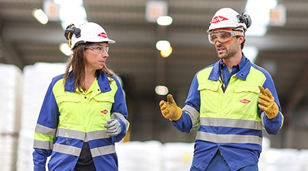 Two employees wearing PPE and talking