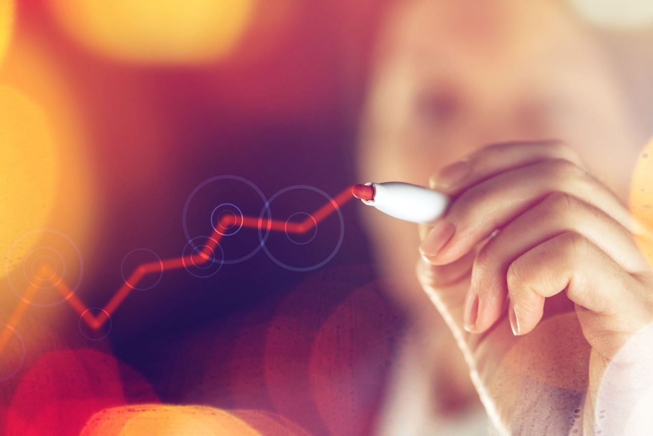 Businesswoman drawing rising graph