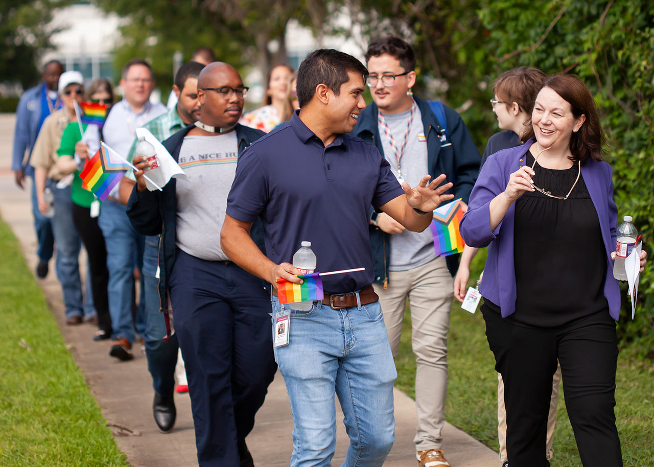 group of people walking some carrying pride flags