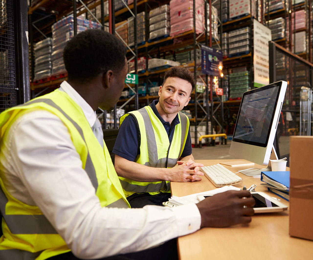 Staff discuss warehouse logistics in an on-site office