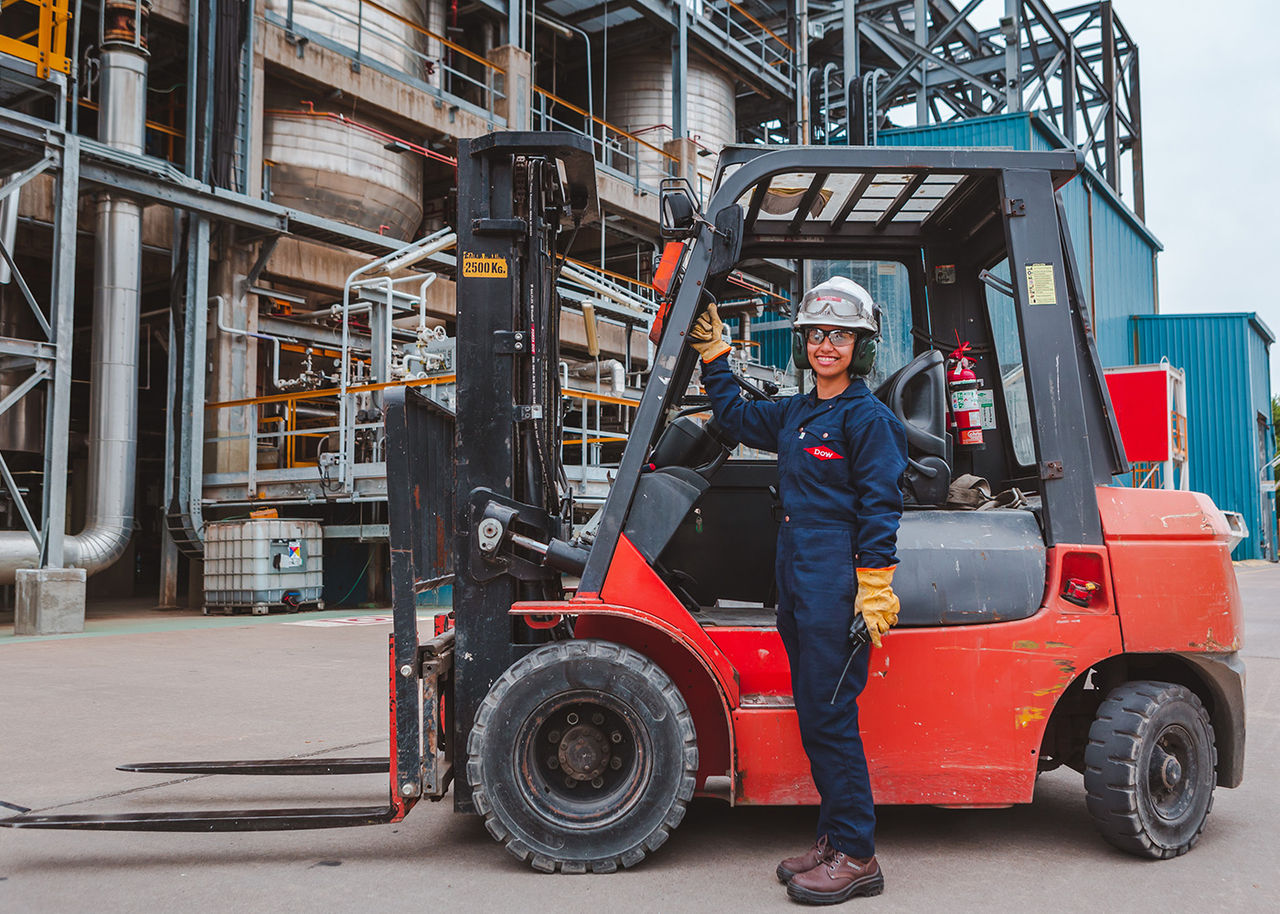 employee next to a forklift in the plant