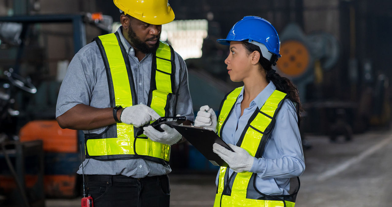 Two warehouse workers look at a tablet