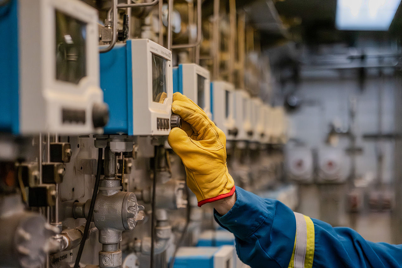 A worker adjusts a dial at the Dow Fort Saskatchewan site