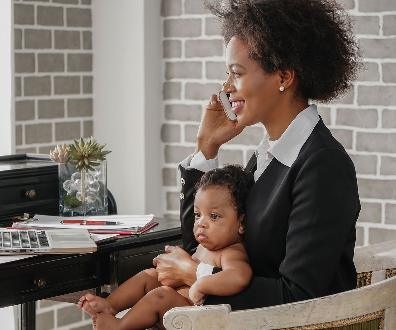 woman holding a baby while working
