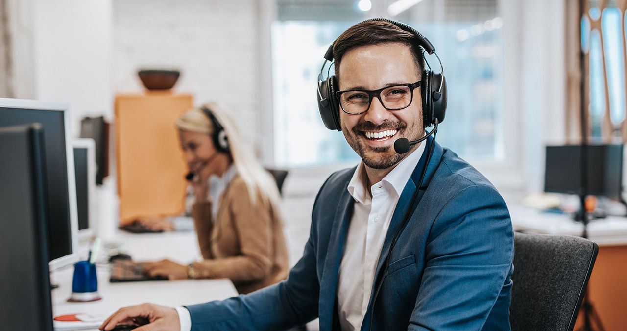 Handsome male customer service agent working in call center office as a telemarketer.