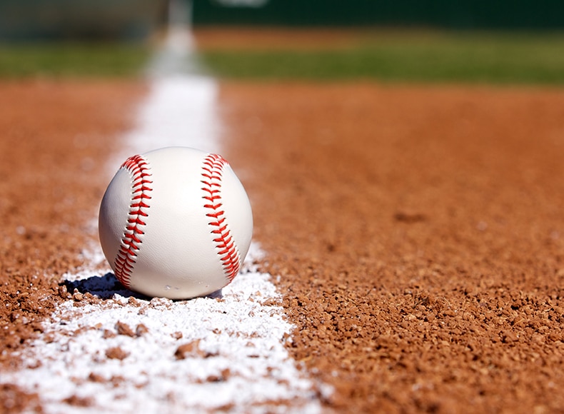 baseball sitting on the foul line in the infield dirt