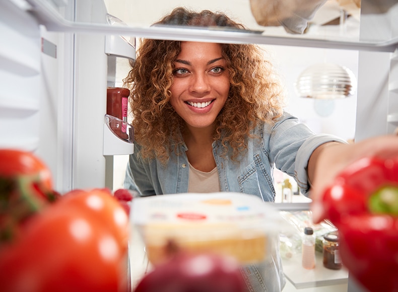 women looking in a refrigerator