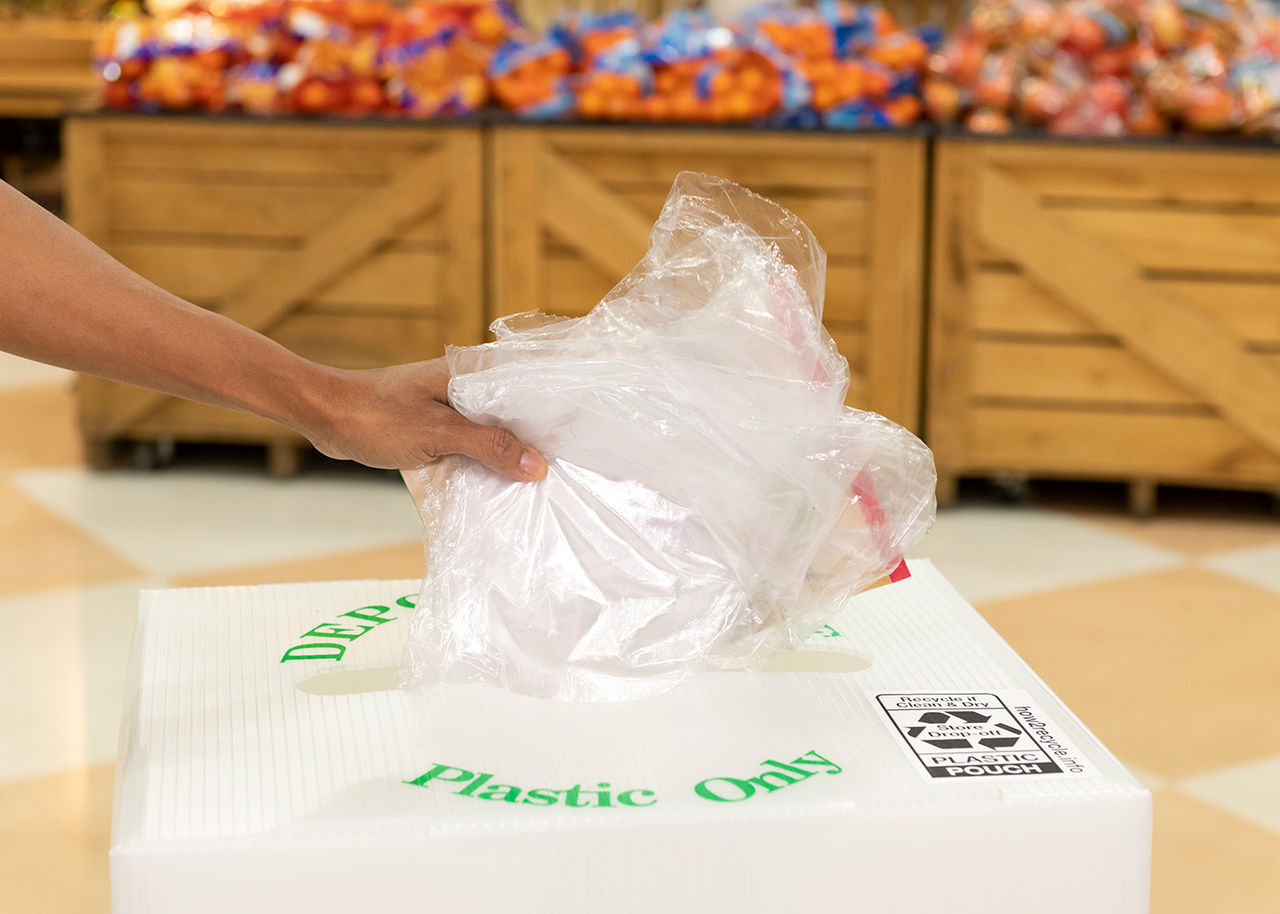 Plastic wrap being placed into a recycling container