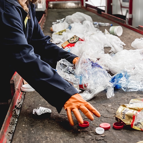worker at recycling plant separates materials