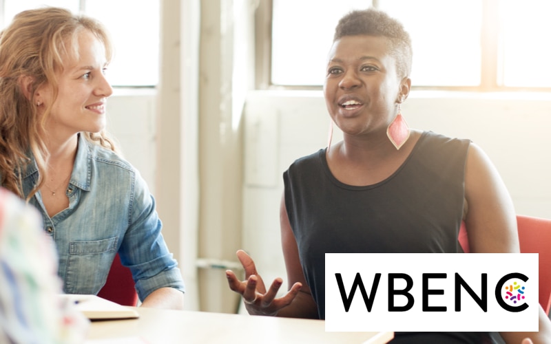 woman speaking in a meeting with the WBENC logo
