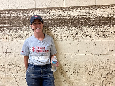 Jess MacDonald, Dow Greyshirt volunteer, shows the high water line that flood waters reached in a community center in Eastern Kentucky.